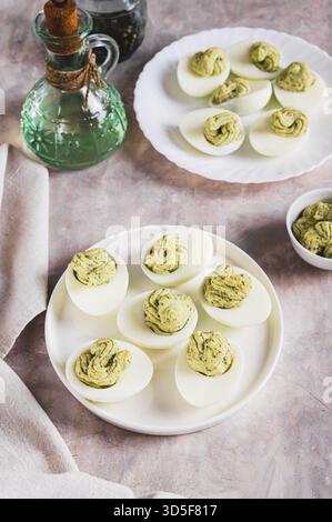 Avocado deviled eggs for appetizer on plate on table vertical view Stock Photo