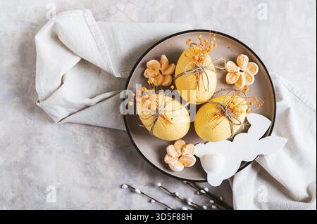 Close up of Easter decorations, decorated eggs and bunny on a plate on the table top view Stock Photo