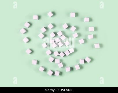 Scattered white sugar cubes on light green background in random pattern Stock Photo