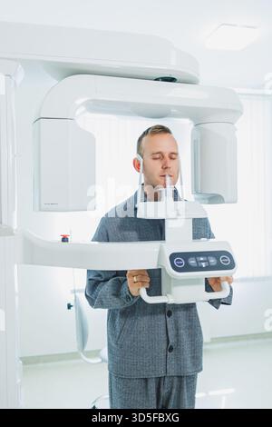 A young man underwent a CT scan of the jaw, a circular image of the jaw in modern dentistry. Radiology, panoramic scanner. Stock Photo