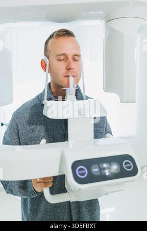 A young man underwent a CT scan of the jaw, a circular image of the jaw in modern dentistry. Radiology, panoramic scanner. Stock Photo