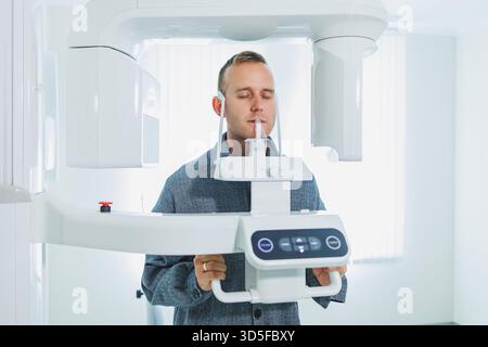 A young man underwent a CT scan of the jaw, a circular image of the jaw in modern dentistry. Radiology, panoramic scanner. Stock Photo