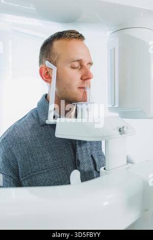 A young man underwent a CT scan of the jaw, a circular image of the jaw in modern dentistry. Radiology, panoramic scanner. Stock Photo