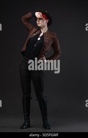 Red-haired lady in steampunk outfit featuring bowler hat with protective goggles Stock Photo