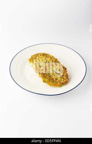 Zucchini fritters, crispy vegetable pancakes on a white plate, isolated Stock Photo
