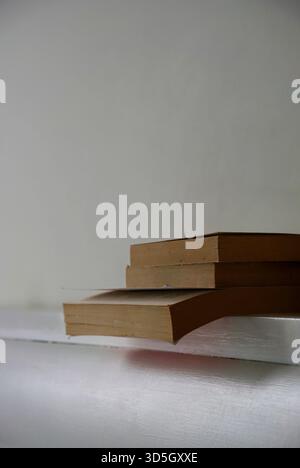 Old books on the bedhead in white background Stock Photo