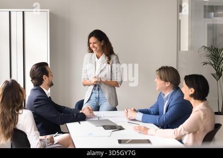 Young woman business trainer involve colleague in discussion on briefing Stock Photo