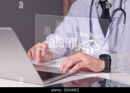 Physician working on laptop with virtual screen displaying cloud backup icon, concept medical data protection, electronic health records, cybersecurit Stock Photo