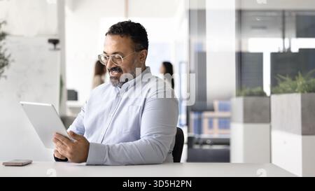 Happy mature Indian business professional man using financial application Stock Photo