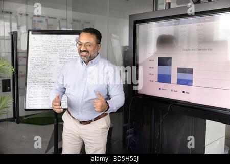 Happy mature Indian executive man presenting project analytic data Stock Photo