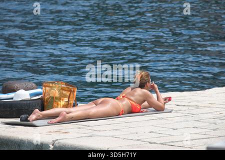 woman in bikini smoking cigarette, Kotor Bay, Montenegro Stock Photo