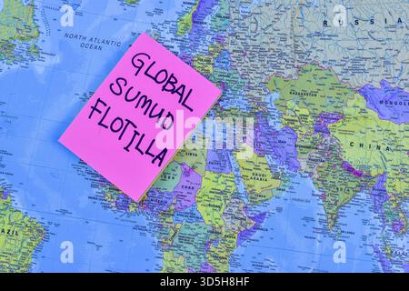 Pink sticky note reading GLOBAL SUMUD FLOTILLA placed on map suggests symbolic maritime initiative tied to resistance and geographic focus. Stock Photo