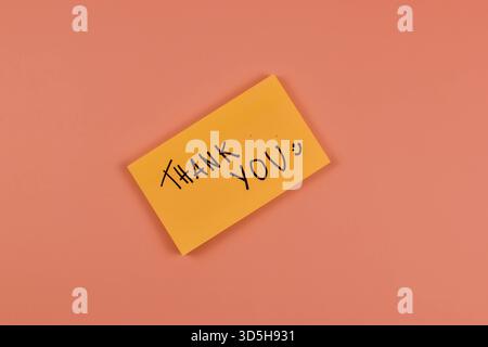 "THANK YOU" card with puzzle pieces on peach background conveys gratitude, connection, and appreciation through minimalistic visual symbolism. Stock Photo