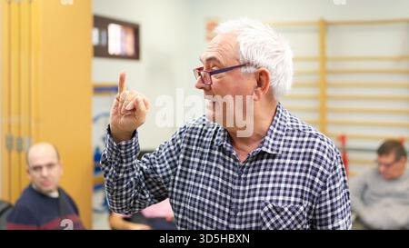 Senior man using sign language, promoting inclusive language Stock Photo