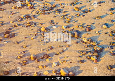Autumn equinox macro of multicoloured pebbles on Irish beach showing sand ripples and natural patterns Stock Photo