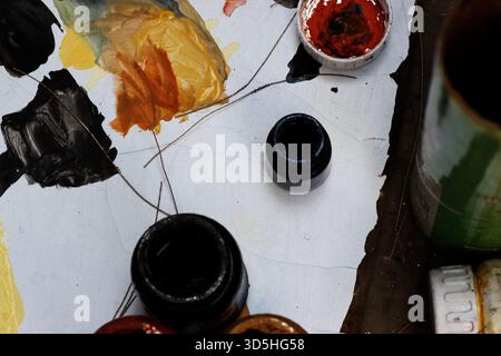 an artists pots of paint and mixes on palette Stock Photo
