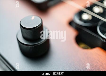 High-resolution close-up of a guitars pickups, showcasing quality metallic components likely made from copper or silver alloy Image emphasizes precisi Stock Photo