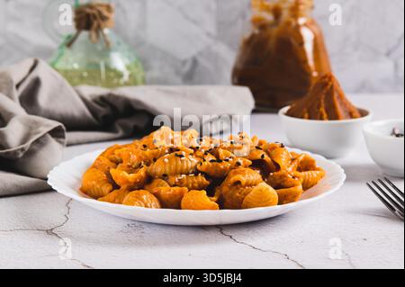 Spicy miso pasta shells on a plate on the table Stock Photo