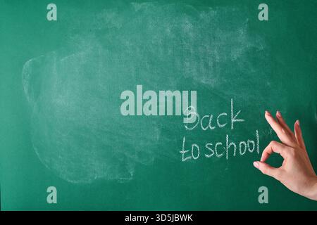 Female teachers hand writing on school board back to school white chalk. Concept back to school. Mock up for design. Copy space. Education Concept. Stock Photo
