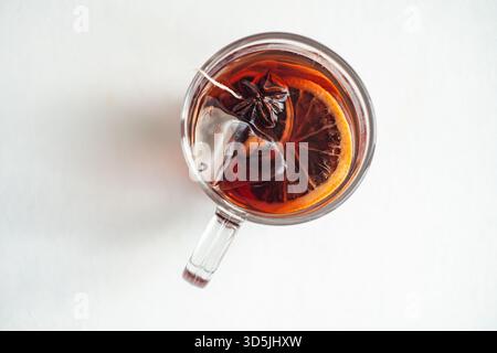 Overhead view of a glass cup with a mulled tea teabag and assorted spices Stock Photo