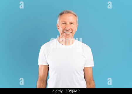 Happy Mature Man Smiling in Studio With Blue Background Stock Photo