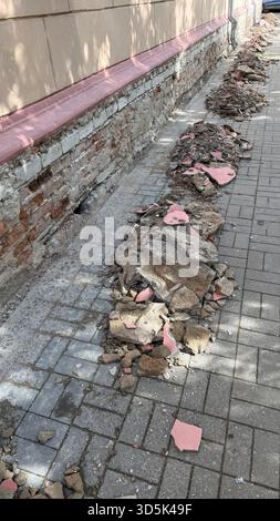 Construction debris on urban sidewalk with broken bricks and rubble, suitable for background. Mobile photo Stock Photo