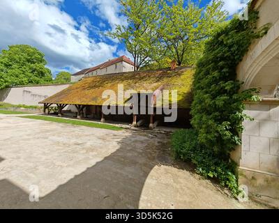 Old stone barn with mossy roof and courtyard Stock Photo