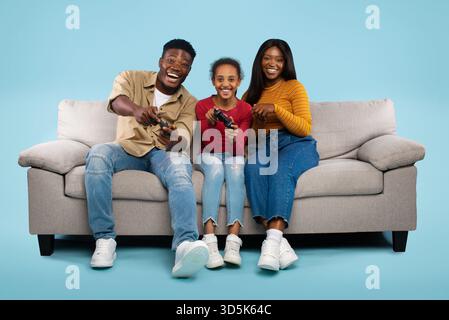 Family Enjoys Gaming Together on a Cozy Couch in a Bright, Cheerful Setting Stock Photo