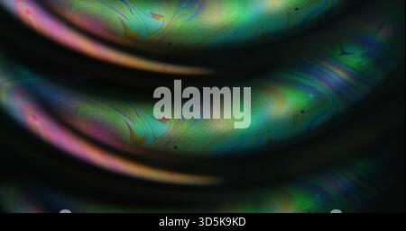 Blur fuel spill. Iridescent art. Blue green orange color flow chemical curve bubble paint neon water floating on abstract dark black background. Stock Photo