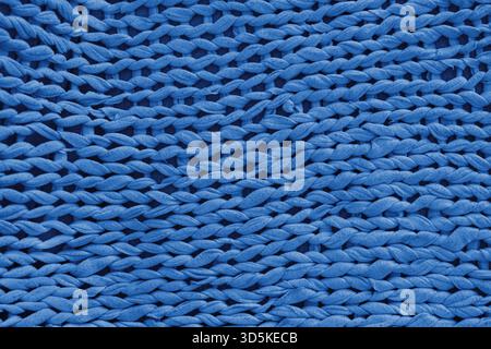 Macro, close up, detailed blue knitted textile, fabric texture with chunky yarn pattern suface. Cozy handmade cloth background, knitwear backdrop , pe Stock Photo