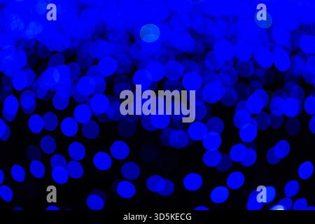 Abstract blue bokeh lights, textured background with glowing circles on dark backdrop. Blurred glowing light circles, festive holiday texture for desi Stock Photo