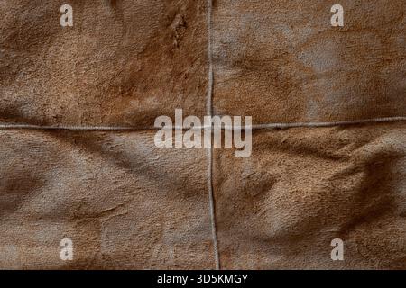 A close-up of a brown suede surface with visible seams. The soft suede texture is suitable as a background Stock Photo