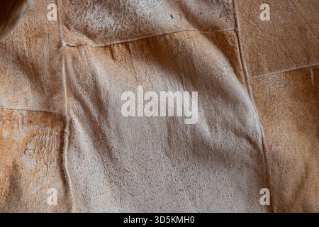 A close-up of a brown suede surface with visible seams. The soft suede texture is suitable as a background Stock Photo