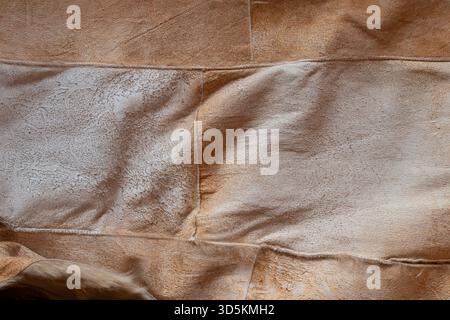 A close-up of a brown suede surface with visible seams. The soft suede texture is suitable as a background Stock Photo