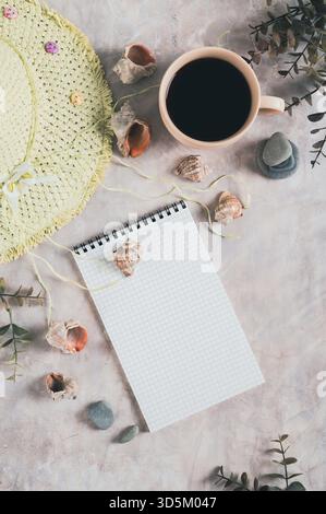 Notebook, beach hat, shells and stones on the table top and vertical view Stock Photo