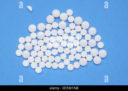 Lots of white pills on a blue background. Search for a cure for COVID-19, medicine concept. Horizontal orientation. Selective focus. View from above Stock Photo