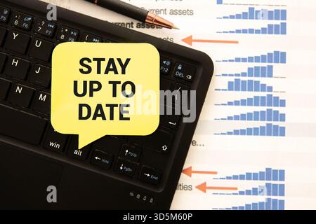 Text STAY UP TO DATE writing on white paper sheet in the black business bag. Business concept Stock Photo
