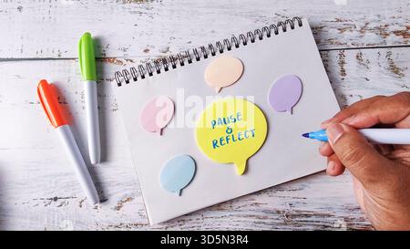 Pause and Reflect Mindfulness Concept with Hand Writing on Speech Bubble Notes and Marker Pens Stock Photo
