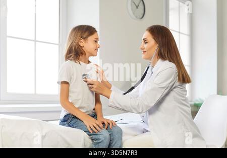 Pediatrician Using Stethoscope To Examine Schoolboy's Lungs In Hospital Stock Photo