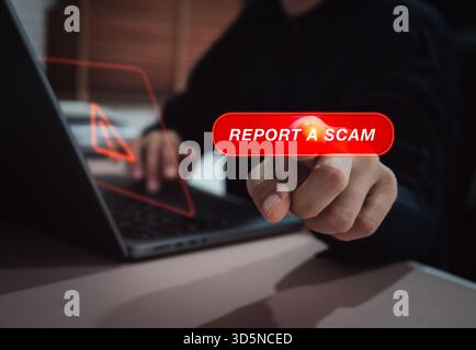 Business person pressing virtual "Report a Scam" red button on digital interface. Concept of cybercrime awareness, online fraud prevention, suspicious Stock Photo