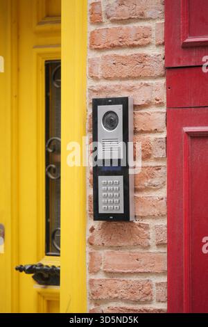 Modern intercom system mounted on a colorful brick wall Stock Photo