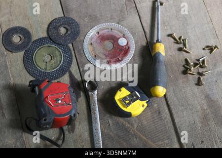 Collection of construction equipment and tool for DIY project. grinder, screwdriver, wrench, and tape measure ready for repair work on wood workshop f Stock Photo