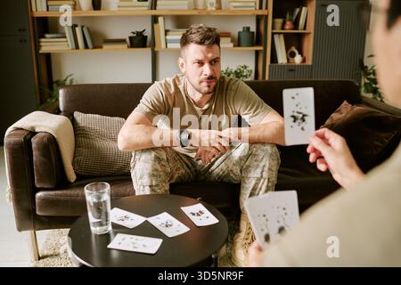 Caucasian Young Adult Man Engaging in Therapeutic Card Game during Counseling Stock Photo