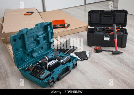 Various tools, including a cordless drill and hammer, ready for furniture assembly or repairs. Stock Photo