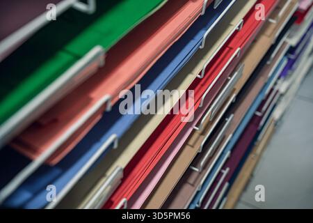 A close-up view of neatly organized colorful a1 papers stacked in a filing system, showcasing various colors and textures. Stock Photo