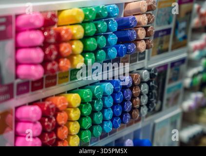 A vibrant assortment of markers in various colors neatly arranged on shelves, showcasing their packaging and labels in an art supply store. Stock Photo