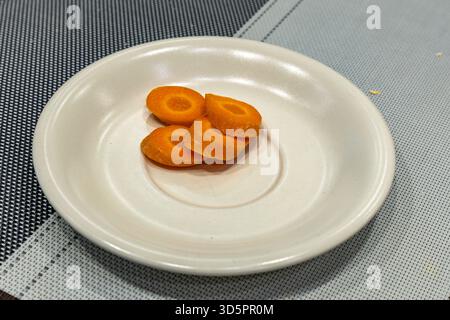 Thinly sliced ​​orange carrots placed on a plate in the kitchen Stock Photo