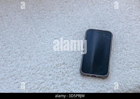 A company cell phone with the display turned off is placed on a white sofa, boncle material Stock Photo