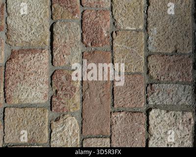 Historic rough natural stone paving in the old town with brown and beige color nuances Stock Photo