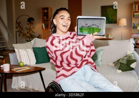 Portrait of Young Adult Caucasian Woman with Disability Displaying Digital Artwork Stock Photo